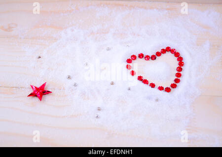 In Herzform aus roten Sterne Ornamente auf weißes Pulver Stockfoto