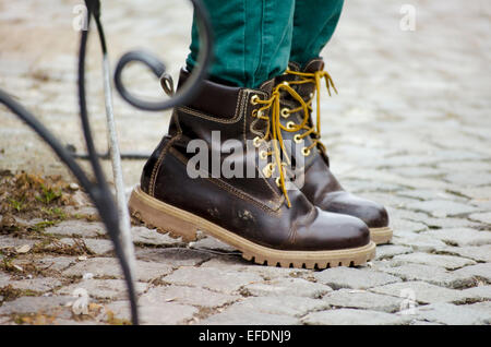 Schmutzige Frauen Winterschuhe Leder auf einer asphaltierten Straße Stockfoto