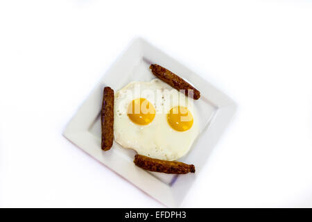 Speck, Würstchen und Eiern auf einem weißen Teller Stockfoto