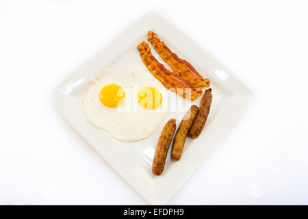 Speck, Würstchen und Eiern auf einem weißen Teller Stockfoto