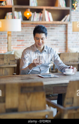 Junger Mann mit Smartphone im café Stockfoto