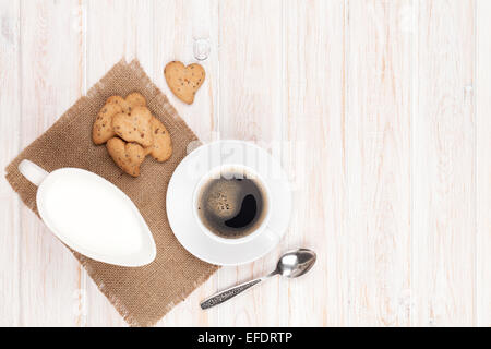 Kaffeetasse, geformte Herzen, Lebkuchen und Milch Krug. Auf weißer Holztisch mit Textfreiraum Stockfoto
