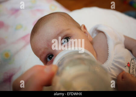 Ein zehn Wochen alten Babymädchen ist Flasche gefüttert von ihrem Vater. Foto Tim Clayton Stockfoto