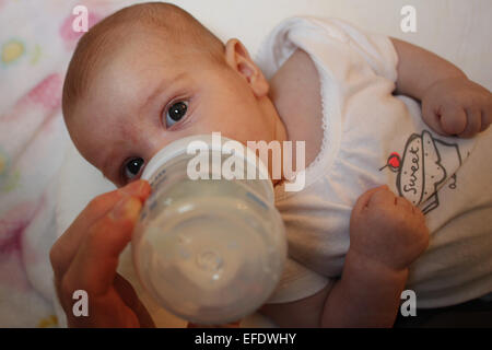 Ein zehn Wochen alten Babymädchen ist Flasche gefüttert von ihrem Vater. Foto Tim Clayton Stockfoto