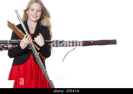 junge blondes Mädchen hält Holzblasinstrumente im Studio vor weißem Hintergrund Stockfoto