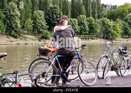 Junge kaukasische Paar in der Liebe, umarmt, Umarmung auf einem Fahrrad am Fluss Po. Valentinstag. Romantik, Liebe, Zärtlichkeit, Umarmung. Turin, Italien, Europa, EU Stockfoto