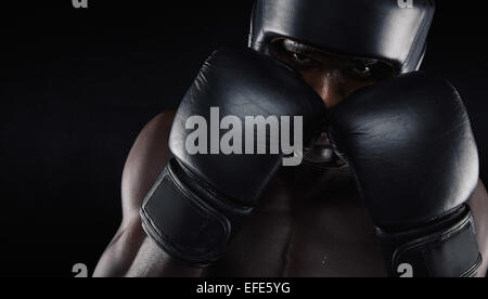 US-amerikanischer Boxer tragen von Schutzkleidung vor schwarzem Hintergrund. Junger Mann Boxen trainieren. Stockfoto