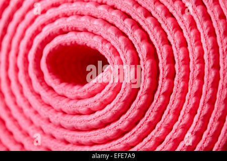 Rosa Yogamatte gebunden durch schwarze elastische gerollt Stockfoto