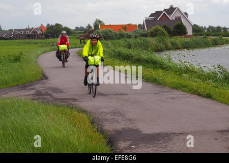 Zwei Radfahrer Fahrrad auf einem Radweg entlang des Flusses Amstel, am Stadtrand von Amsterdam. Stockfoto