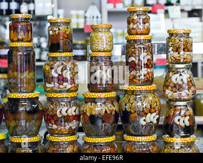 Glasgläser mit Nüssen und Honig auf dem Display in einem Geschäft im Hintergrund Stockfoto
