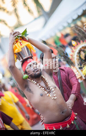 Hindu Mann Carring Kavadi auf dem Kopf mit einem Spieß über seine Wangen am Thaipusam 2015, Batu Caves, Malaysia Stockfoto