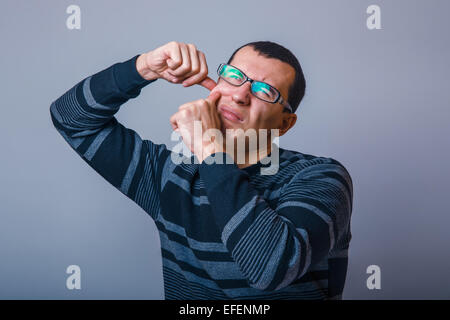 Europäisch anmutende Mann von etwa dreißig Brunet einen Pickel quetschen Stockfoto