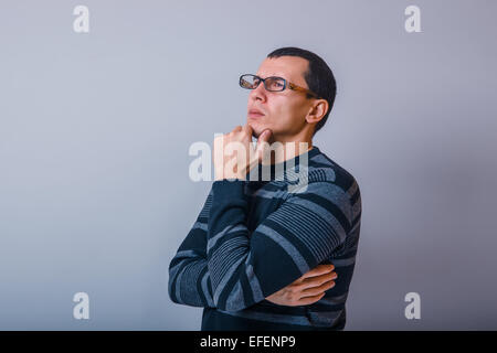 Männchen der Europäischen Erscheinungsbild Brunet hält Hand am Kinn denken Stockfoto