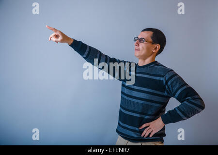 Männchen der Europäischen Erscheinungsbild Brunet auftaucht seine Hand auf eine graue b Stockfoto