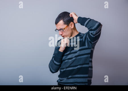 Männchen der Europäischen Erscheinungsbild brunet denken auf grauem Hintergrund Stockfoto
