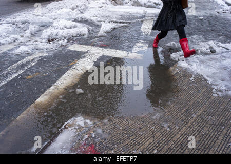 Fußgänger finden Ochsentour durch Pfützen, Matsch und Schnee an Straßenkreuzungen mit Schnee dam verstopfte Abflüsse im Stadtteil Chelsea in New York am Montag, 2. Februar. 2015. New Yorker auf dem Weg zur Arbeit konfrontiert geht es allen, Frost, Regen, Schnee und einfache Regen wie ein Sturm durch die Stadt. Temperaturen werden voraussichtlich fallen und mit mehr Niederschlag der bestehenden Matsch und stehendes Wasser schaltet auf gefährliche Eis.  (© Richard B. Levine) Stockfoto