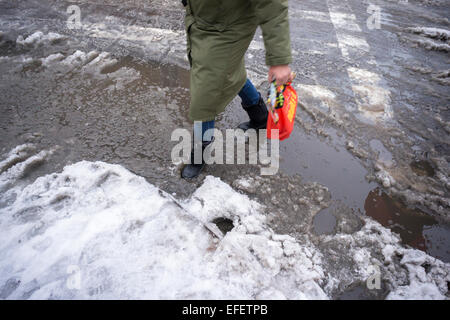 Fußgänger finden Ochsentour durch Pfützen, Matsch und Schnee an Straßenkreuzungen mit Schnee dam verstopfte Abflüsse im Stadtteil Chelsea in New York am Montag, 2. Februar. 2015. New Yorker auf dem Weg zur Arbeit konfrontiert geht es allen, Frost, Regen, Schnee und einfache Regen wie ein Sturm durch die Stadt. Temperaturen werden voraussichtlich fallen und mit mehr Niederschlag der bestehenden Matsch und stehendes Wasser schaltet auf gefährliche Eis.  (© Richard B. Levine) Stockfoto