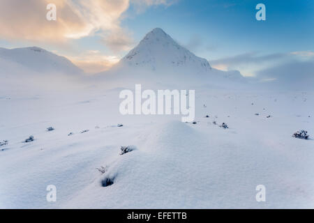 Wee Buachaille bedeckt mit einer dicken Schicht Schnee war die Sonne hinter dem Berg war. Stockfoto
