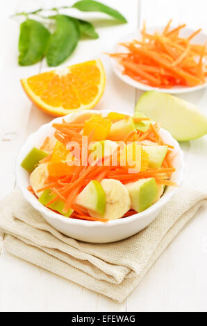 Gesunde Ernährung. Obstsalat mit Karotten, Äpfel, Bananen und Orangenscheiben Stockfoto