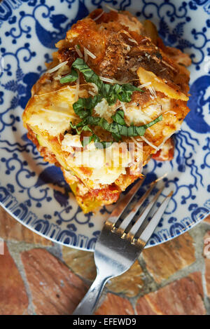 Lasagne, sitzt auf einem Teller mit einer Gabel herausragen. Food-Fotografie. Ansicht von oben Stockfoto