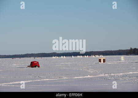 Eisangeln auf zugefrorenen See, Winterszene, Angeln, kalten Wintertag, Fischerhütten auf Schnee Stockfoto