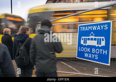 Fußgänger warten auf eine Stadtbahn übergeben im Stadtzentrum von Manchester. Stockfoto