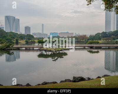 Japanische Gartenlandschaft und Wolkenkratzer spiegelt sich im Wasser am Hama-Rikyu Onshi-teien Stockfoto