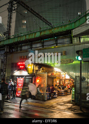 Menschen Essen in traditionellen Tokio Restaurants unter den Bahnlinien Stockfoto