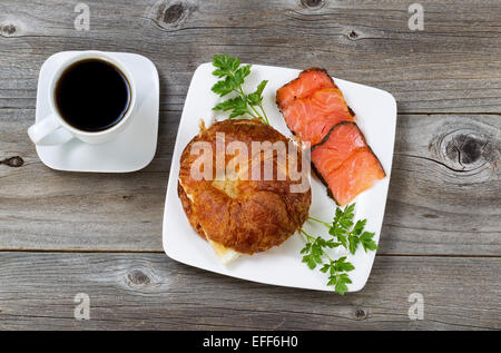 Ansicht von oben Winkel von Frühstück mit frisch gebackenen Croissants, mit Ei, kalt geräucherter Lachs, Petersilie auf Seiten- und schwarzer Kaffee Stockfoto