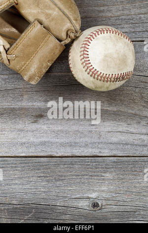 Vertikale Draufsicht Winkel der alten Baseball und verwittert Leder Mitt auf rustikalen Holz. Viele Textfreiraum. Stockfoto