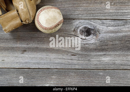 Horizontale Draufsicht Winkel der alten Baseball und verwittert Leder Mitt auf rustikalen Holz Stockfoto