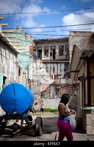 Havanna, Kuba. 28. Januar 2015. Eine Frau zu Fuß ging ein verfallenes Wohnhaus in Havanna, Kuba, 28. Januar 2015. Foto: Lisette Poole/Dpa/Alamy Live News Stockfoto