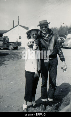 12. Dezember 2014 - Kanada - ca. 1950er Jahre: Reproduktion eines antiken Fotos zeigt einen Mann und eine Frau in einem Hut posiert vor dem Hintergrund des Gebäudes und ein Pickup-Truck. Sie halten einen Hecht in seinen Händen. (Kredit-Bild: © Igor Golovniov/ZUMA Wire/ZUMAPRESS.com) Stockfoto