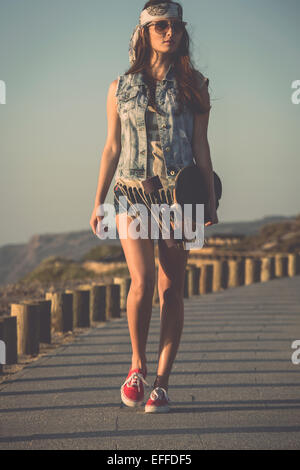 Schöne Skate Mädchen zu Fuß eine Skateboard mit gedrückter Stockfoto