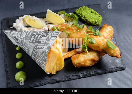Fish &amp; Chips, Tempura-Teig, matschig Erbsen, Erbsen Püree, Zitronenspalten und raffinierte Zahnstein malen Stockfoto