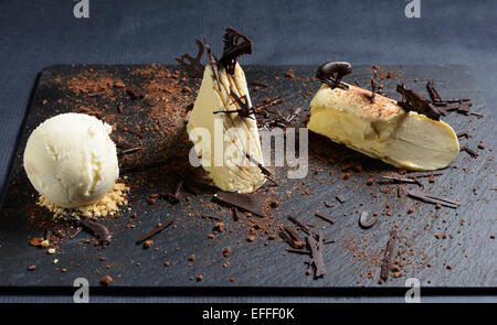 Weiße Schokolade und Vanille-Parfait mit Schokoladen Streusel auf einem schwarzen Schiefer Teller Stockfoto