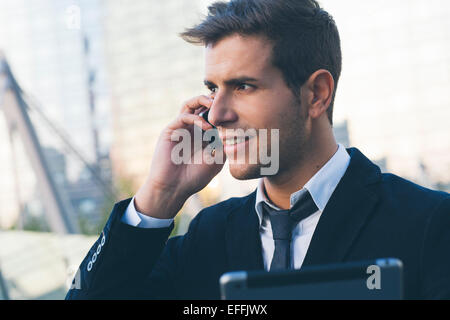Geschäftsmann mit einem Mobiltelefon und einem digital-Tablette Stockfoto
