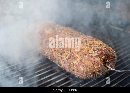 Schweinefilet im Speckmantel auf Grill gewickelt Stockfoto