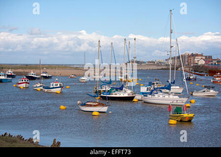 Boote vor Anker in der Kimnel Bay in North Wales, mit der Promenade am Rhyl im Hintergrund. Stockfoto