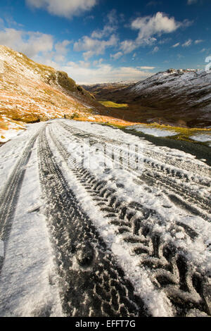 Reifenspuren auf Wrynose Pass im Winter, Lake District, Großbritannien. Stockfoto