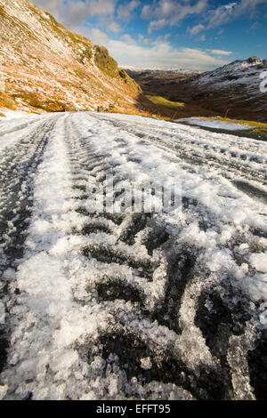 Reifenspuren auf Wrynose Pass im Winter, Lake District, Großbritannien. Stockfoto