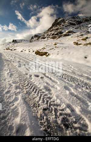 Reifenspuren auf dem Wrynose-Pass die geschlossen wurde, durch Schnee und Eis, Lake District, Großbritannien Stockfoto