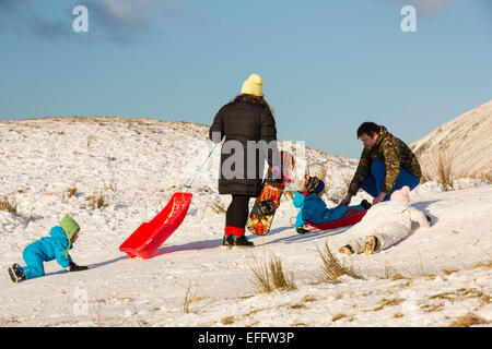 Eine Familie, Schlittenfahren auf Kirkstone Pass im Lake District, UK. Stockfoto