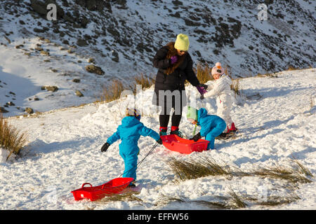 Eine Familie, Schlittenfahren auf Kirkstone Pass im Lake District, UK. Stockfoto