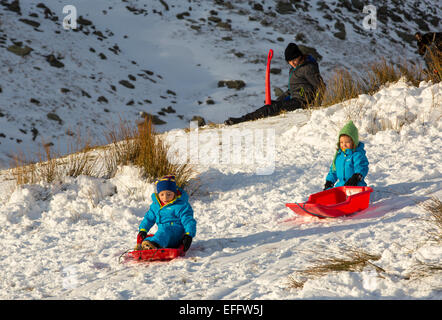 Eine Familie, Schlittenfahren auf Kirkstone Pass im Lake District, UK. Stockfoto