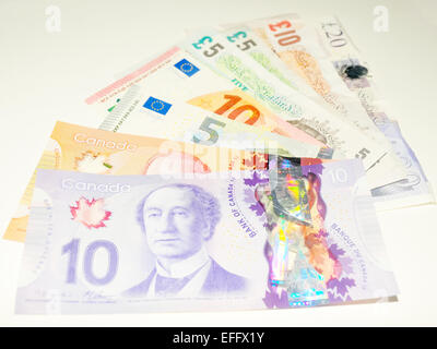 Britische Pfund-Noten, kanadischen Dollar-Noten und europäischen Euro-Banknoten vor weißem Hintergrund fotografiert. Stockfoto