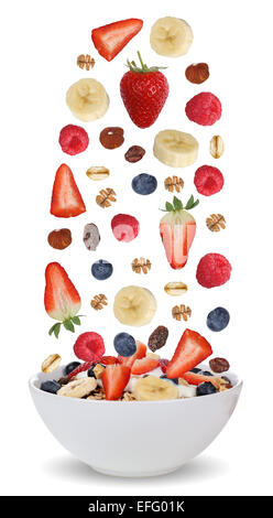 Zutaten von Früchte-Müsli zum Frühstück in Schüssel mit Früchten wie Himbeeren, Heidelbeeren, Bananen und Erdbeeren Stockfoto