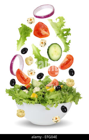 Fallende Salat in Schüssel mit Salat, Tomaten, Feta-Käse, Zwiebel, Oliven und Gurken Stockfoto