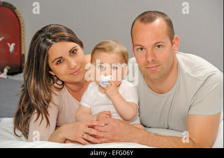 Eltern kuscheln neugeborenes Baby Boy zu Hause Stockfoto