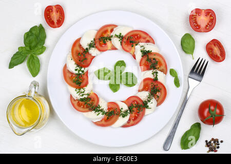 Zutaten für Caprese-Salat mit Tomaten und Mozzarella von oben auf einem Holzbrett Stockfoto